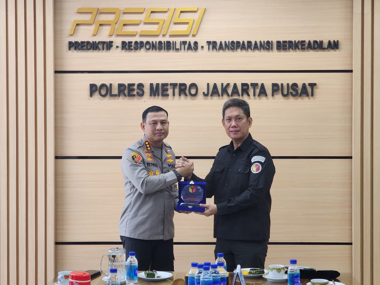 Penyerahan cinderamata kepada Kapolres Metro Jakarta Pusat sebagai simbolis kerjasama yang berkelanjutan dalam pengawasan pemilu.